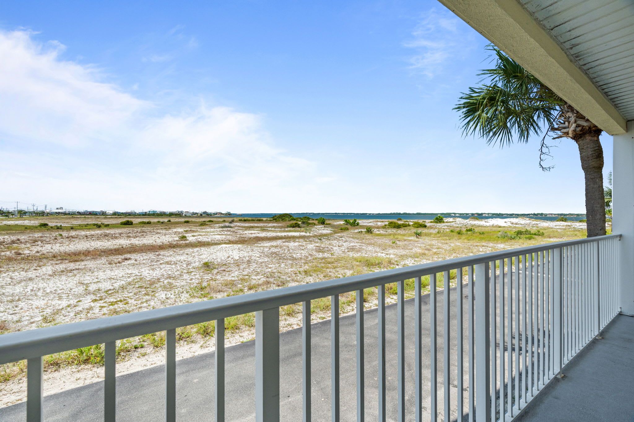 A balcony with a view of a beach and ocean.