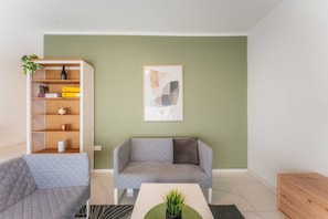 A modern living room with a sofa, a bookshelf, and a coffee table. - Spacious 4BR 4 Bath in Piet Up to 8 Guests (Pieta)