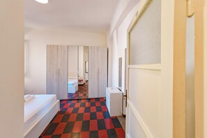 Ein Hotelzimmer mit einem Bett, einem kleinen Schreibtisch, einem Spiegel und einem karierten Boden.