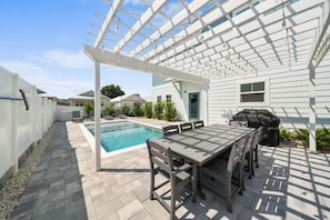 A covered patio with a pool, outdoor furniture, and a pergola. - Downtime Panama Palms | Pool, Beach, Pet-Friendly (Panama City Beach)