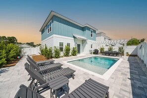 A two-story house with a swimming pool, outdoor seating, and a pergola. - Downtime Panama Palms | Pool, Beach, Pet-Friendly (Panama City Beach)