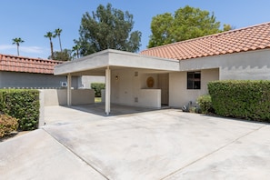 A single-story building with a covered patio area, a garage, and a small window. - Inverness on the Green | Golf Course Views | Modern 2BR | Pool & Tennis | Palm Desert (Palm Desert)