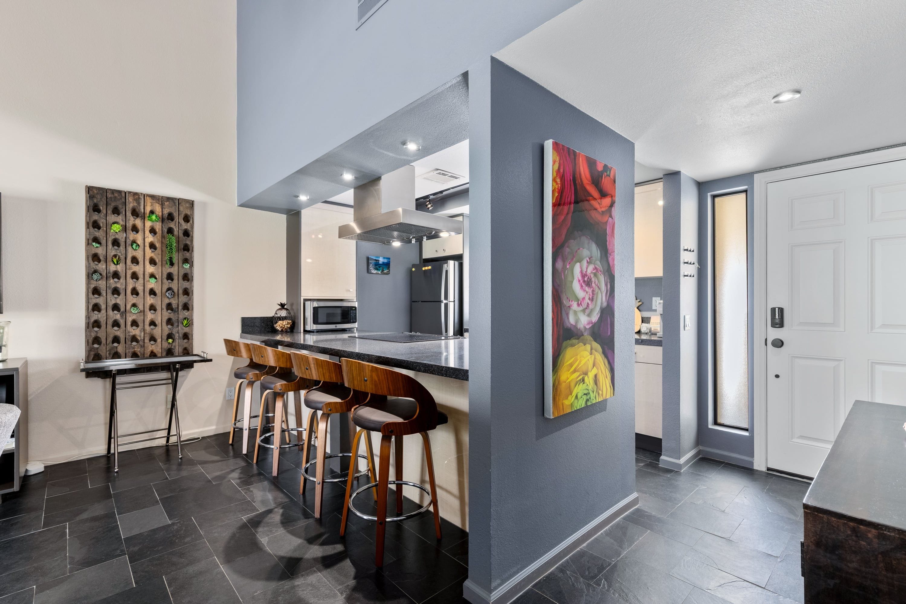 Una cocina moderna con barra, un panel decorativo y un ventanal grande.