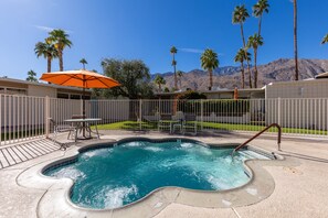 A swimming pool with a hot tub, surrounded by a fenced patio area with outdoor furniture. - Mod Pad 2.0 | Historic Ocotillo Lodge | Pool (Palm Springs)