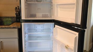 An open refrigerator with multiple shelves and a freezer compartment.