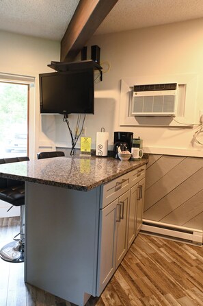A kitchen with a granite countertop, a coffee maker, a toaster, and a microwave. - NEW rental Shanty Creek Resorts 1 bedroom on the Schuss course walk to slopes (Mancelona)