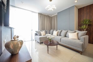 A modern living room with a grey sofa, a round coffee table, and a large vase. - Mazatlán Luxury Beach Residence - 606TN - Camino al Mar (Mazatlán)
