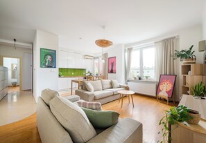 Una sala moderna con un sofá, una mesa de comedor y una cocina al fondo.