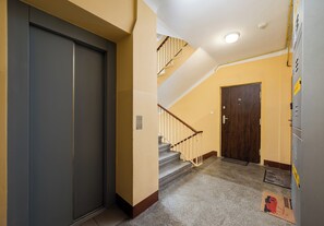 Ein Flur mit einer geschlossenen Tür, einer Treppe und einer Tür mit der Nummer 15.
