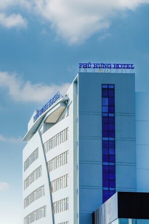 A hotel building with a sign reading 'PEU HING HOTEL' and a modern architectural design.