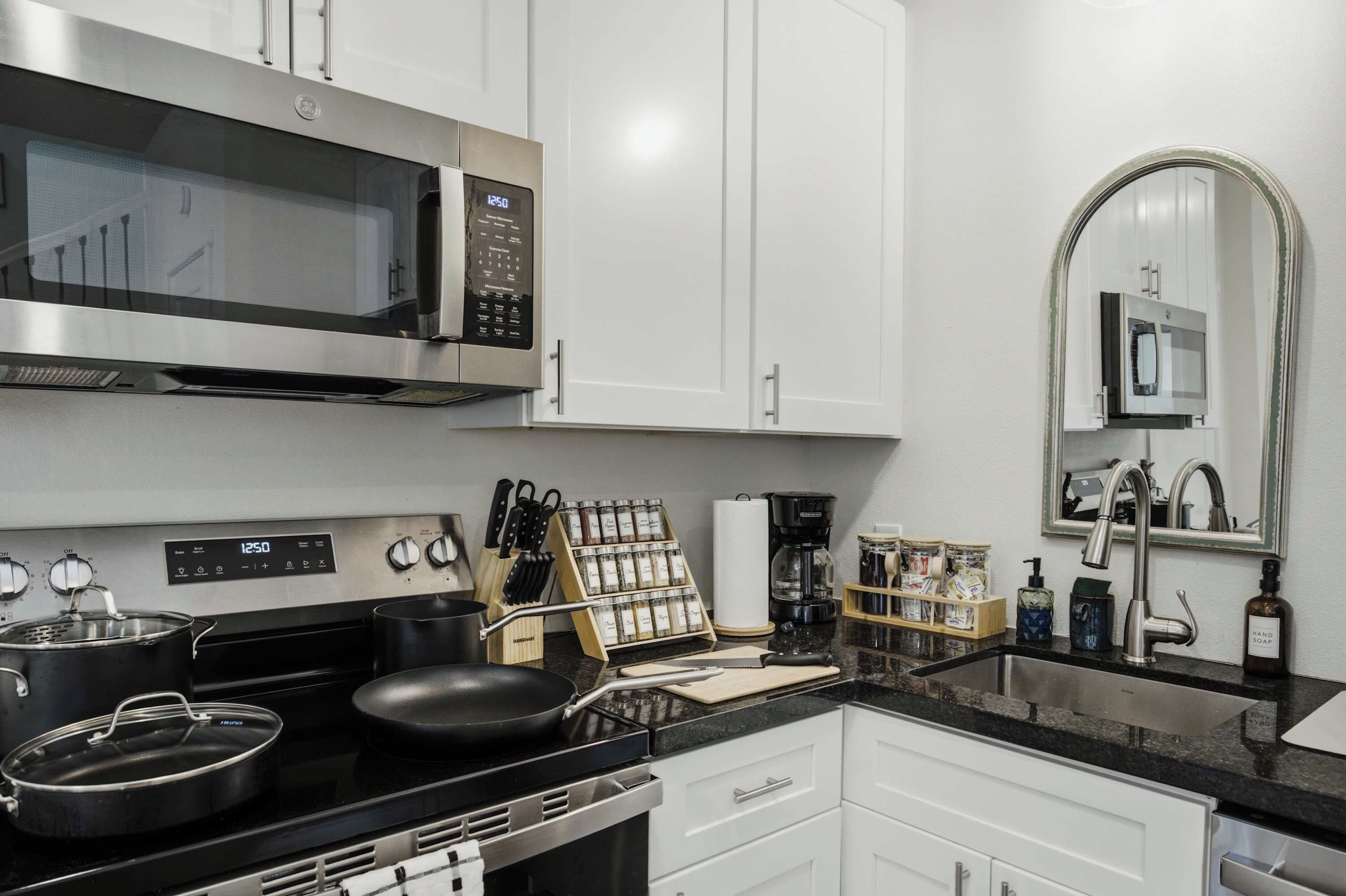 Una cocina moderna con electrodomésticos de acero inoxidable, un microondas, una estufa y un lavabo.