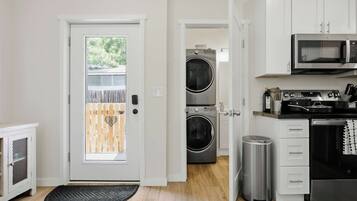 Una cocina compacta con microondas, horno y lavamanos.