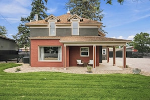 A two-story house with a covered patio area. - The Evergreen Home | King Beds + Fire Pit (Loveland)