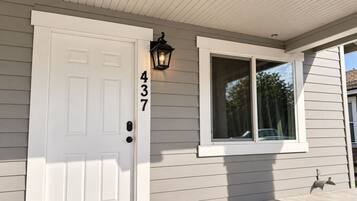 A house with a white door, a black mailbox, and a window with a white frame.