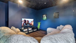 A modern living room with a flat-screen TV, comfortable sofas, a small plant, and a framed picture on the wall. - Hibernation Station by Avantstay Hot Tub + Theater Room + Mtn Views Mins to Dollywood + Smokies (Sevierville)