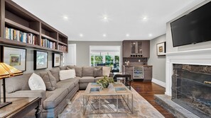 A modern living room with a sectional sofa, a coffee table, and a fireplace.