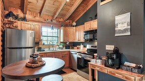 A modern kitchen with wooden cabinets, stainless steel appliances, and a coffee bar. - Happy Trails by Avantstay Wraparound Deck + Hot Tub Near Dollywood + Pigeon Forge (Sevierville)