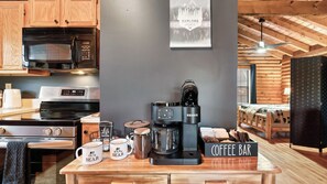 A kitchen with a coffee bar, a microwave, and a Keurig coffee maker. - Happy Trails by Avantstay Wraparound Deck + Hot Tub Near Dollywood + Pigeon Forge (Sevierville)