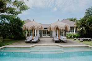 A poolside area with lounge chairs and a pool.