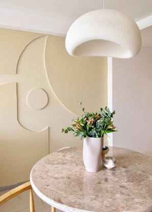 A round marble table with a white vase containing green plants. - Beautiful apartment in the heart of Polanco (Mexico City)
