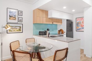 A modern kitchen with a central island, wooden cabinets, and a stainless steel refrigerator. - Funky Teneriffe - 2bed-2bath-balcony-1car (Brisbane)