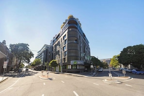 A modern building with a curved facade, a visible entrance, and a sign indicating a 2P parking area. - Funky Teneriffe - 2bed-2bath-balcony-1car (Brisbane)
