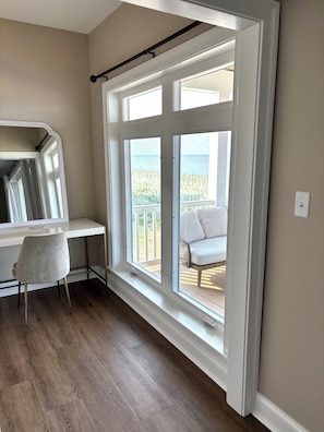 A room with a large window, a desk, and a chair. -  New luxurious beachfront home with saltwater pool (Milton)