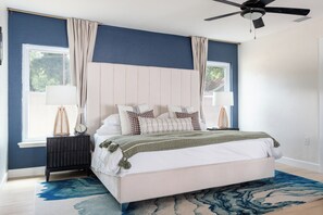 A bedroom with a bed, bedside tables, a ceiling fan, and a window with curtains. - Luxe 4BR/3BA • Heated Pool + Gym, 5 Min Downtown (Austin)