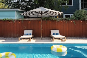 A swimming pool with two lounge chairs and an umbrella. - Luxe 4BR/3BA • Heated Pool + Gym, 5 Min Downtown (Austin)