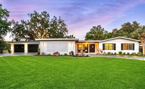 A modern two-story house with a garage, a well-maintained lawn, and a driveway. - Lakefront 3BR Monthly Snowbird Rental, Private Pool, near The Villages (Fruitland Park)