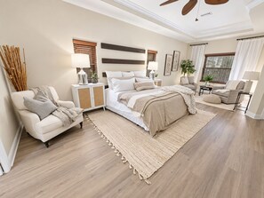 A bedroom with a bed, bedside tables, a chair, a sofa, and a large window. - Perfect 4-bedroom house with AC in charming Cape Coral (Cape Coral)