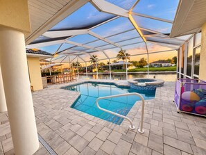 A covered outdoor swimming pool area with a view of a residential neighborhood. - Perfect 4-bedroom house with AC in charming Cape Coral (Cape Coral)