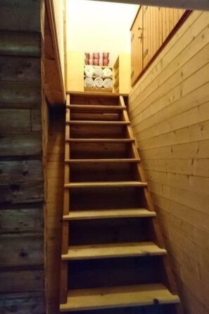 A wooden staircase leading to a room with a bed and a window. - Haus am See by Interhome (Frymburk)