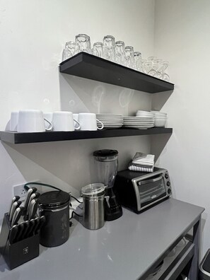 A kitchen counter with a coffee maker, toaster, and utensils.