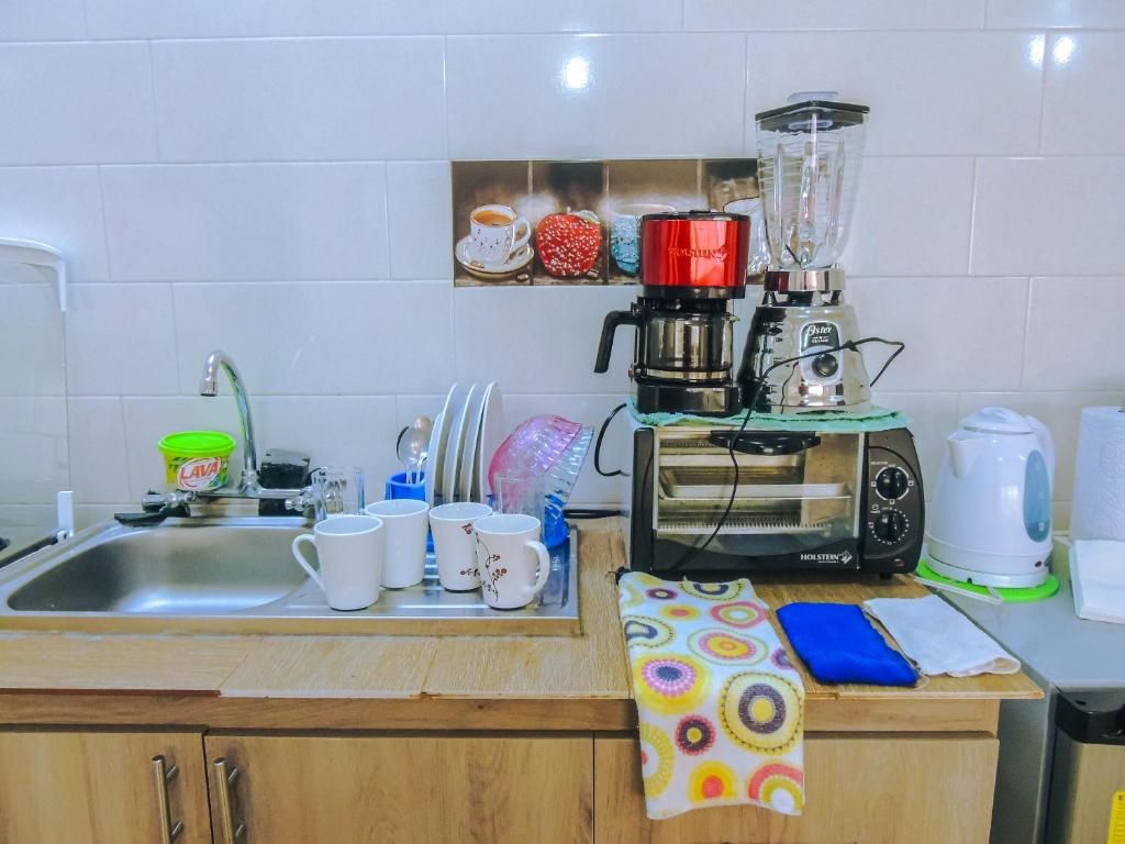 Een keuken met een spoelbak, koffiezetapparaat, blender, broodrooster en waterkoker.