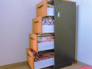 Een garderobe met verschillende vakken, lades en een deur met sleutelgat.