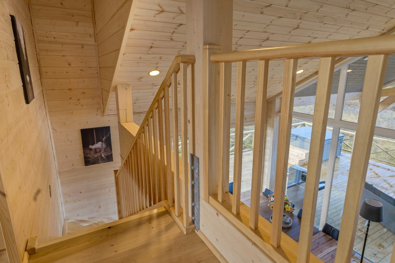 A wooden staircase with a railing leading to an upper level.