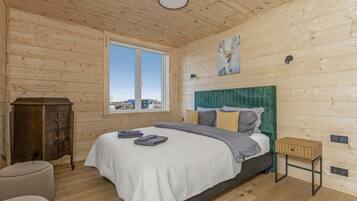 A bedroom with a bed, a window, a cabinet, and a painting.