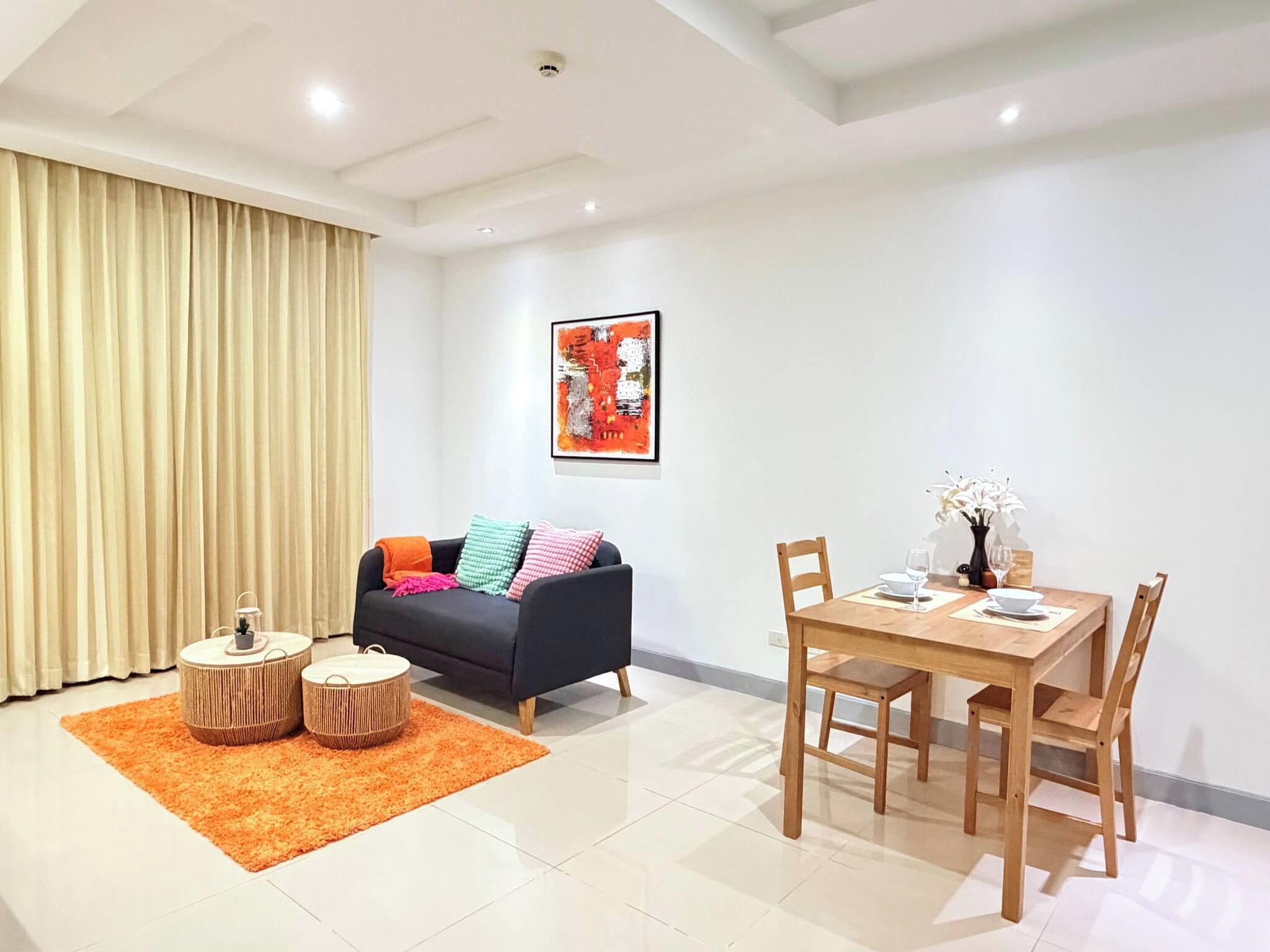 A modern living room with a sofa, coffee table, and dining table.