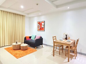 A modern living room with a sofa, coffee table, and dining table. - Room-tc Contel at Charan Phrom Phong - F (Bangkok)