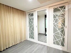 A room with a sliding door, a curtain, and a mirror. - Room-tc Contel at Charan Phrom Phong - F (Bangkok)