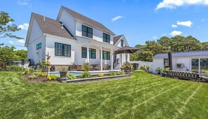 A two-story house with a large front porch, a swimming pool, and a covered patio area. - The Inn on Turville Creek + 6 Waterfront Cottages (Berlin)