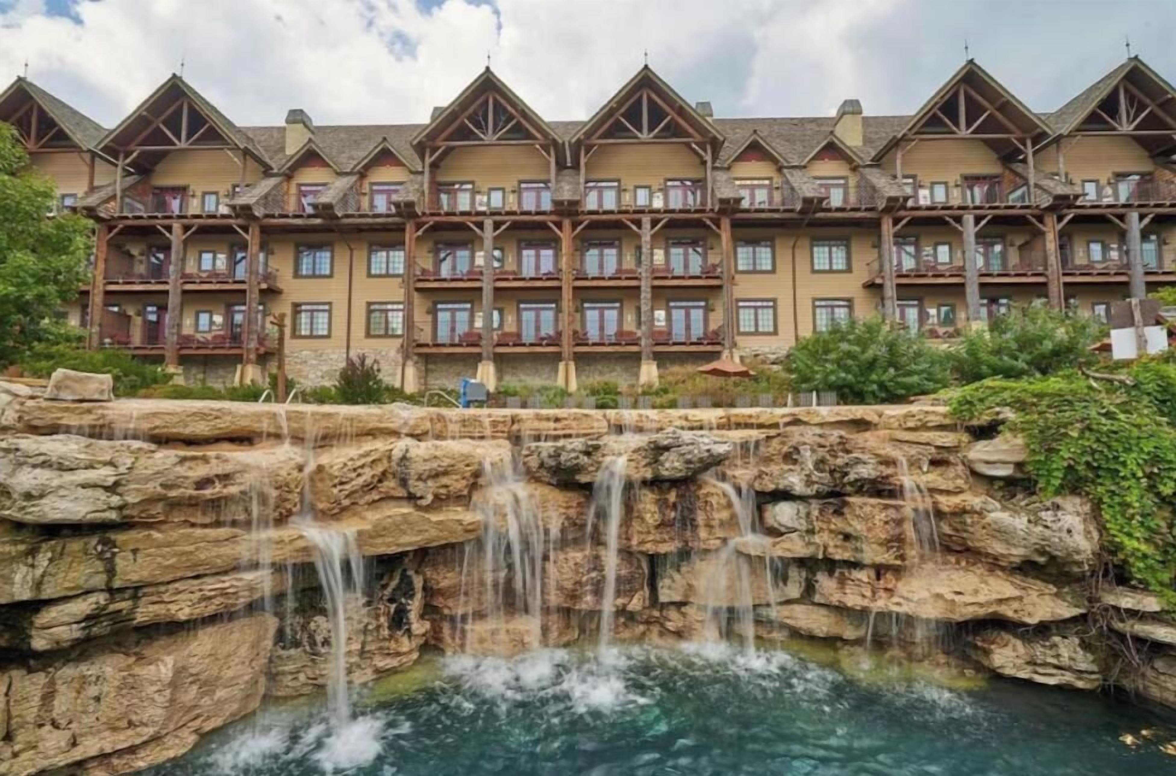 Un hôtel à plusieurs étages, agrémenté d’une cascade artificielle en pierre à l’avant.