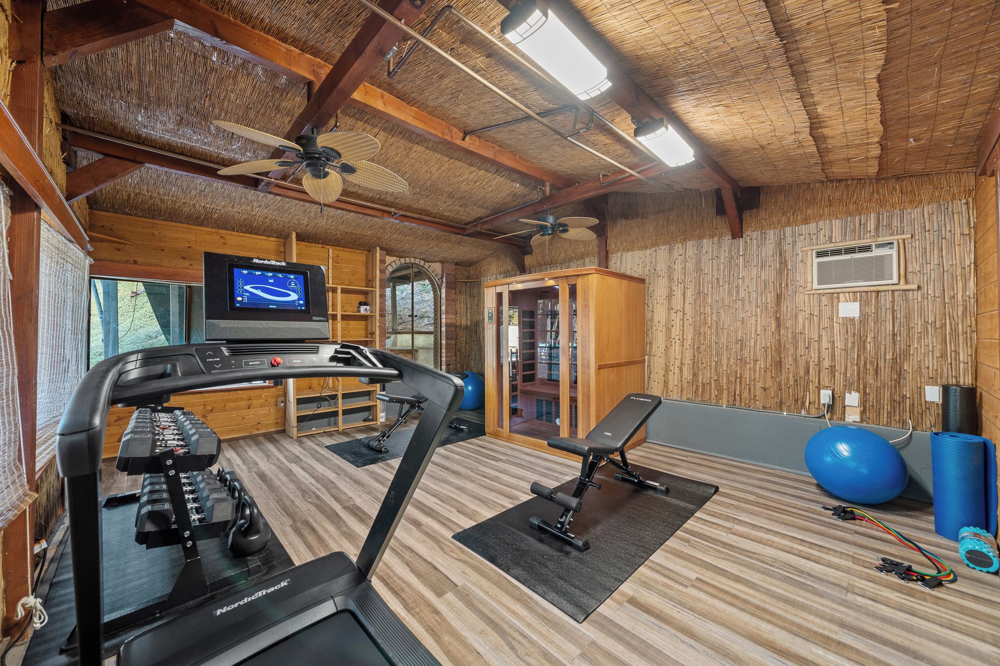 A gym with treadmills, a stationary bike, and exercise balls.