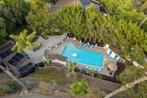 An aerial view of a residential property with a swimming pool, lounge chairs, and surrounding greenery. - Entire Private Home with 3 Beds, Pool, Sauna, Gym, Parking Yard, Ranch Style (Spring Valley)