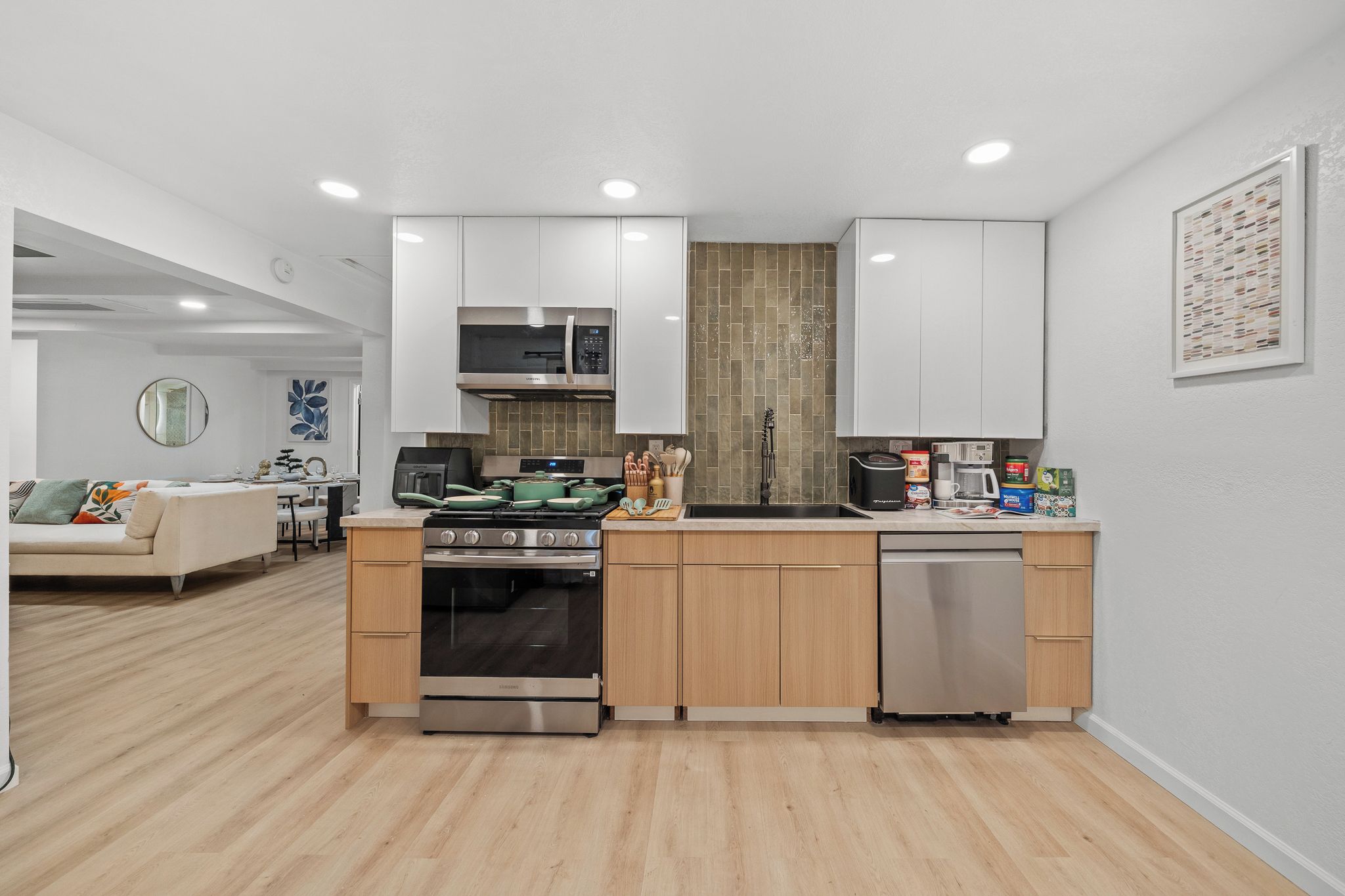 A compact kitchen with white cabinets, a built-in oven, and a dishwasher.