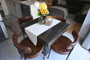 A dining area with a table, chairs, and a vase of flowers. - Modern 4 bedroom house in Milton (Milton)