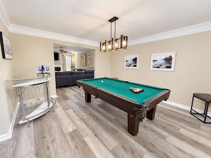 A pool table in a room with a wooden floor, a glass bar, and a ceiling fan. - Spacious Family Retreat Near Stone Mountain Park and Lake Lanier Island (Snellville)