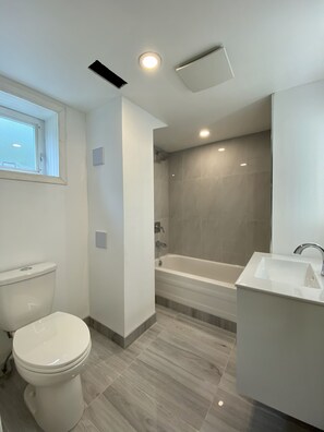 Ein modernes Badezimmer mit Toilette, Badewanne und Waschbecken.