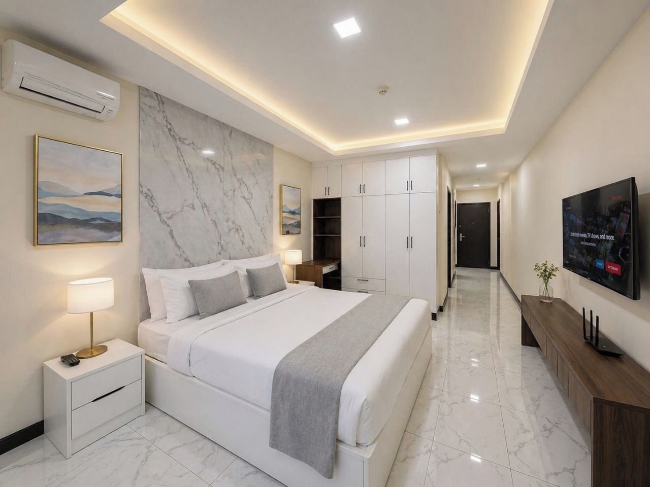 A modern bedroom with a large bed, bedside tables, a TV, and a marble wall.